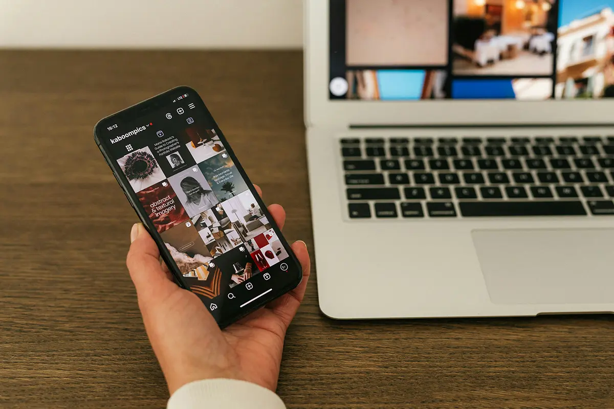 A hand holding a smartphone displaying an Instagram profile grid, illustrating effective content curation as part of online brand growth strategies.