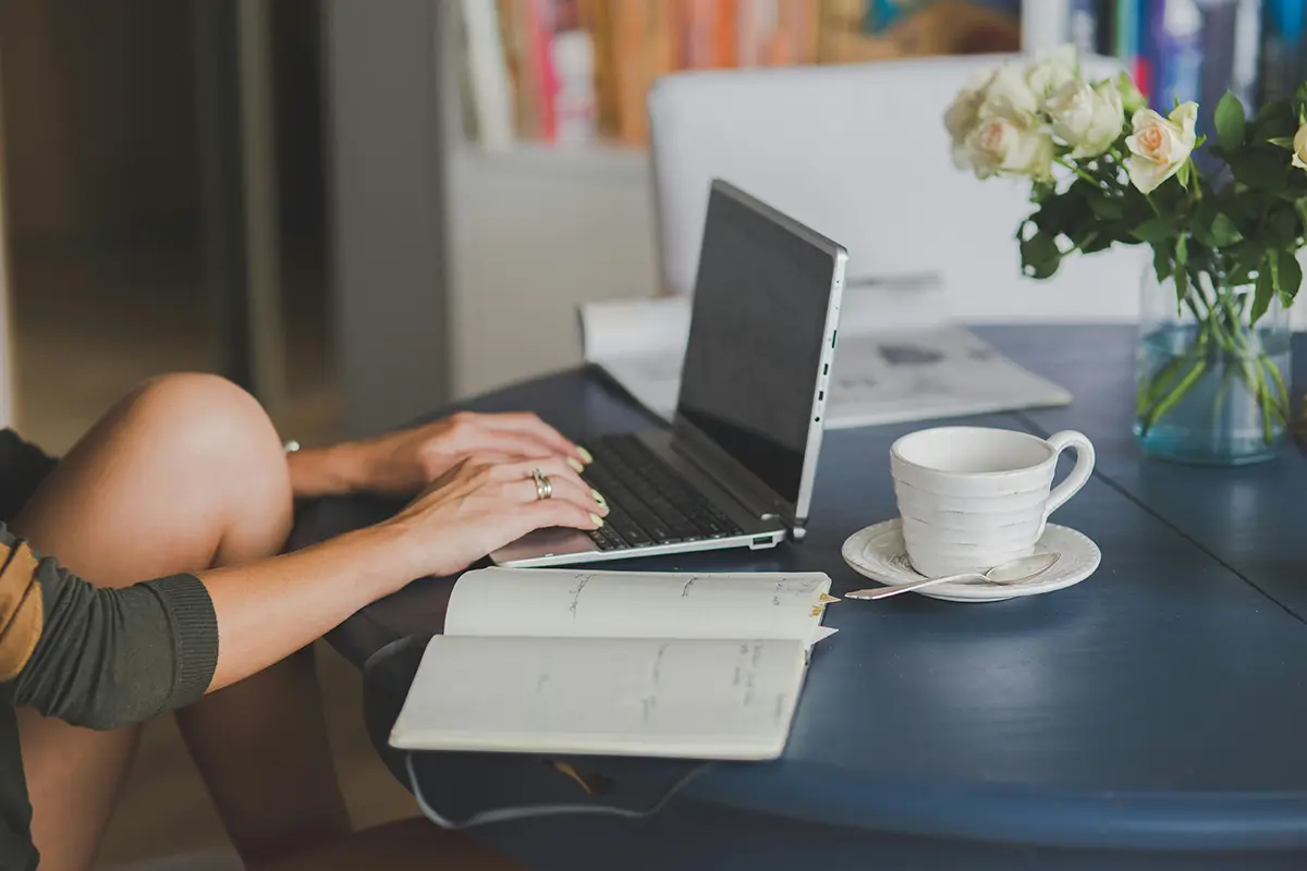 A remote worker managing a digital business on a laptop, demonstrating the practical application of skills learned in The Real World.